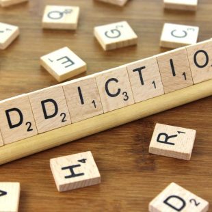 le mot addiction avec des lettres de Scrabble