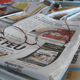 photo en gros plan de journaux et d'une paire de lunettes