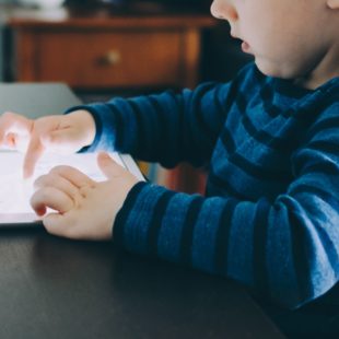 Un enfant utilise une tablette tactile