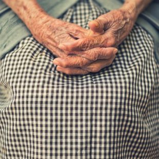 Mains ridées de femme sur sa jupe