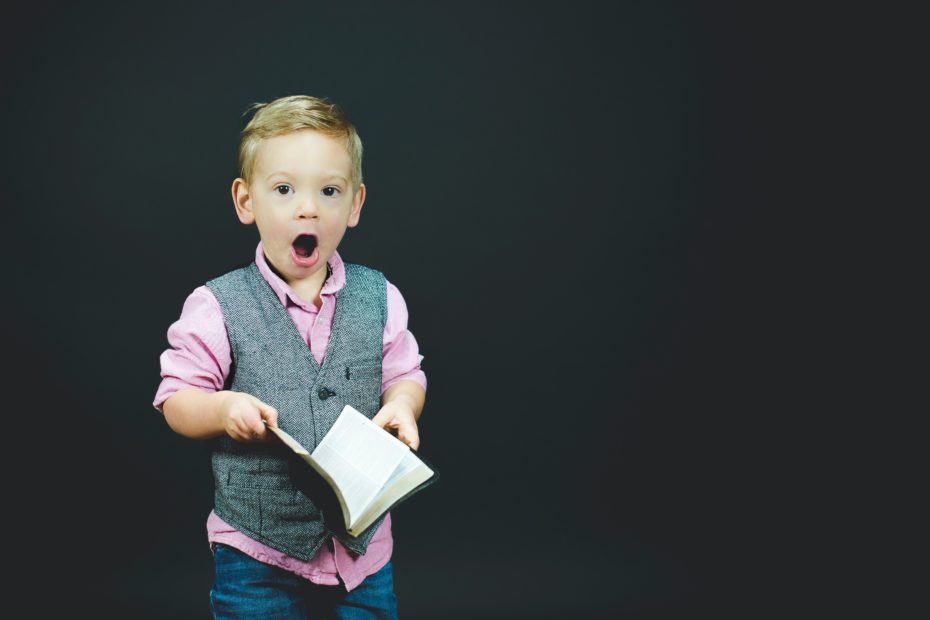 Enfant étonné qui tiens un livre ouvert