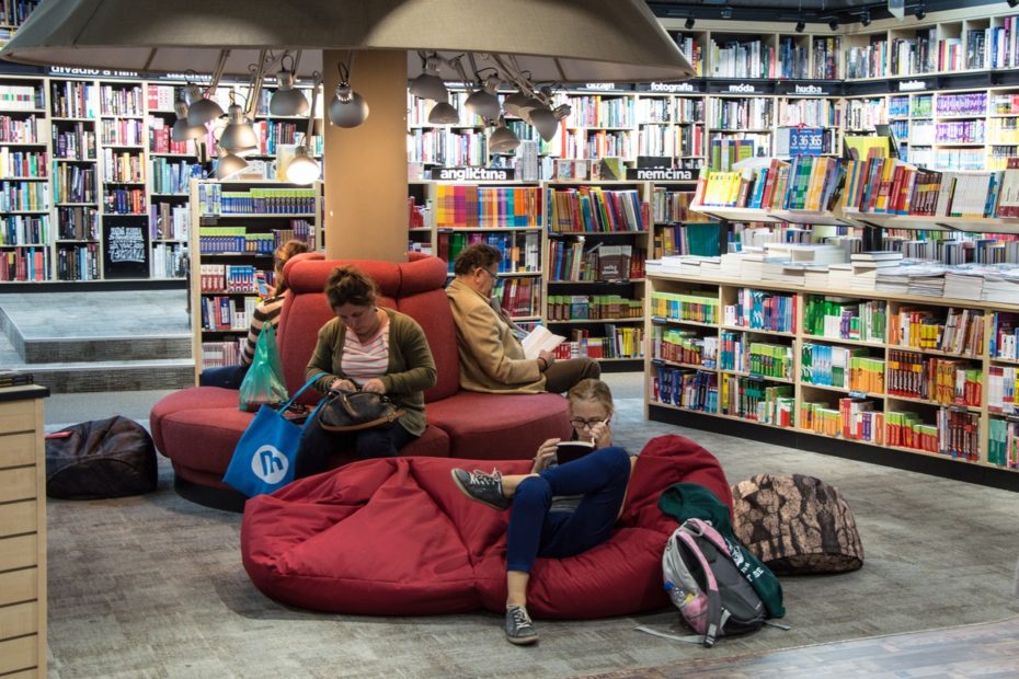 Intérieur d'une bibliothèque avec des usagers lisant dans des poufs