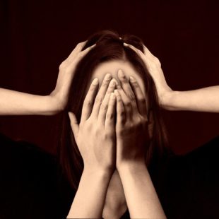 Femme qui se cache les yeux avec les mains