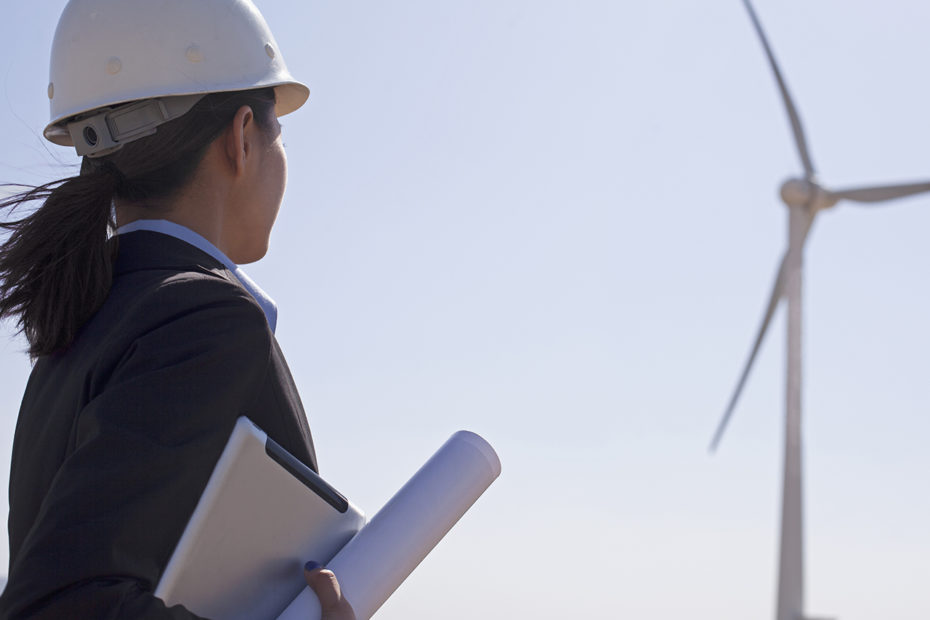 feme ingénieur de profil devant une éolienne