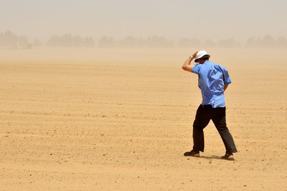 Homme marchant dans une tempête de sable