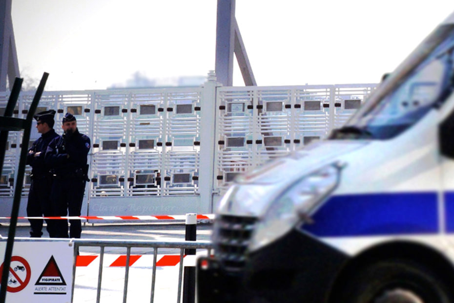 photo d'un car de police devant une barrière et un bâtiment