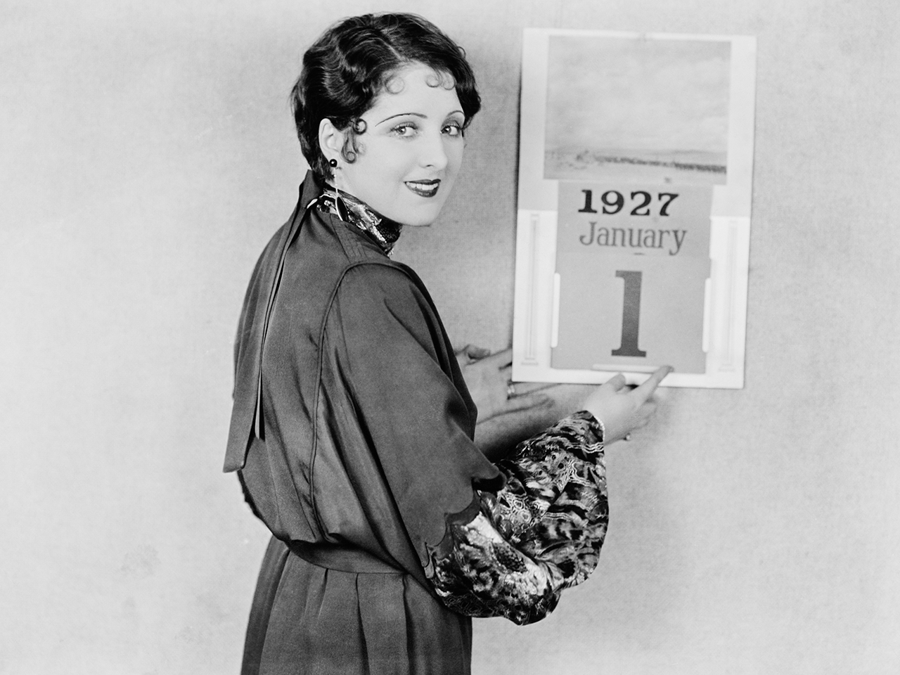 Photographie ancienne d'une femme devant un calendrier