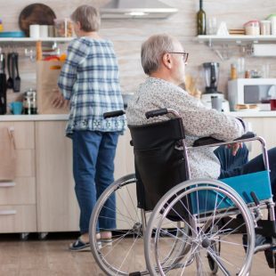 Personne en fauteuil et son aidante dans la cuisine du domicile