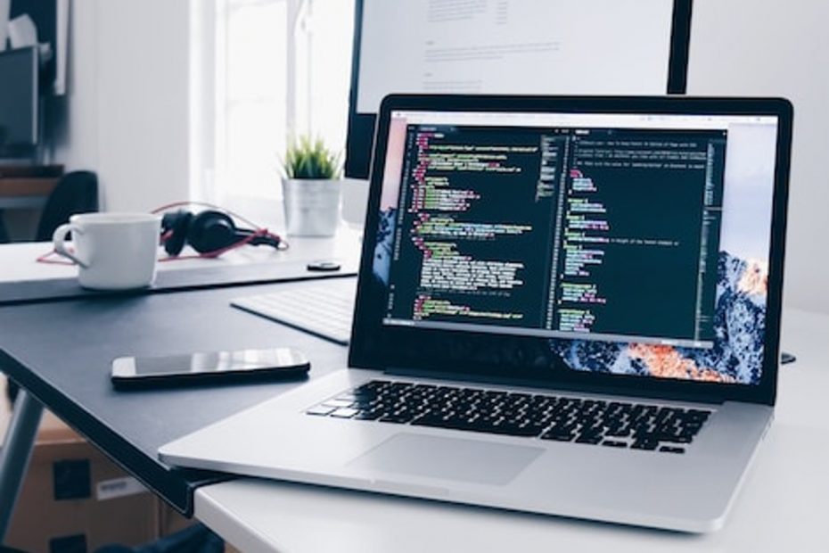 Photo d'un écran d'ordinateur sur un bureau faisant apparaitre des lignes de code