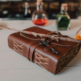 Grimoire et baguette de sorcier posés sur une table
