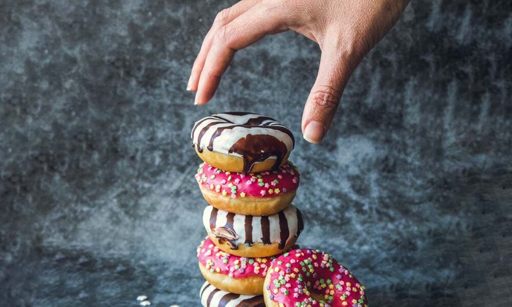 Pile de donuts et main qui prend le premier